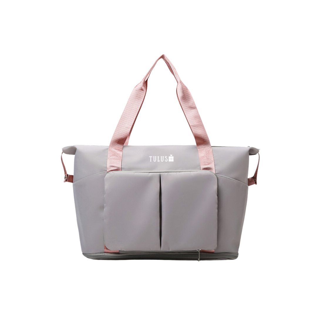 Foldable, expandable and waterproof tote and travel bag in grey with pink handles, spacious, accessible pockets with wet and dry compartments.